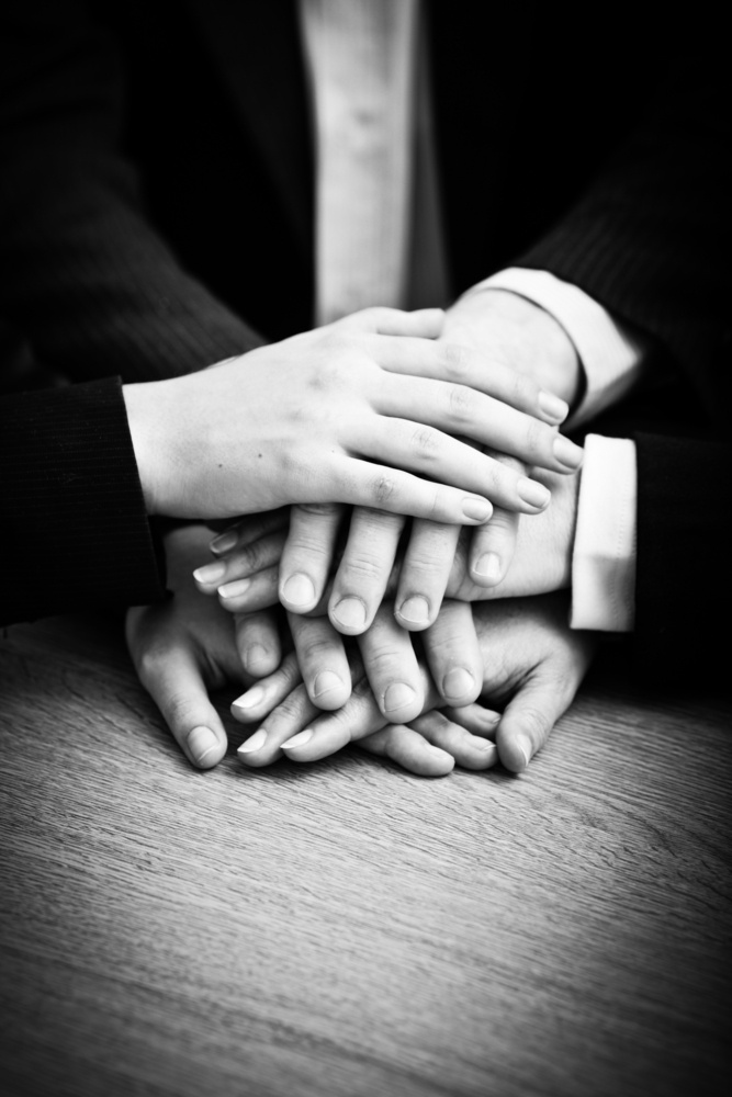 Image of business partners hands on top of each other symbolizing companionship and unity